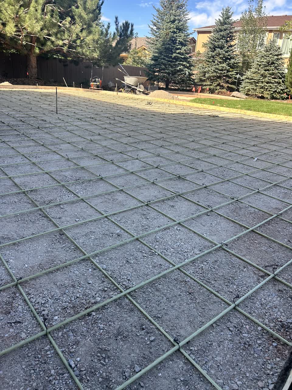 A tied rebar grid set over a compacted gravel base on an Apex Patios job, ready for the pour.