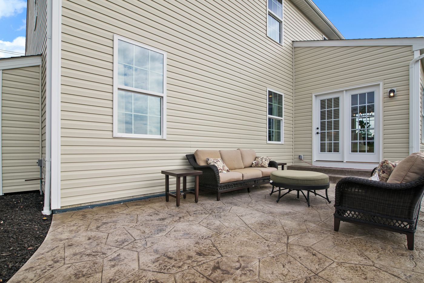 A completed stamped concrete patio furnished as an outdoor sitting area.